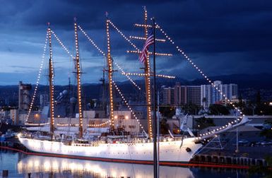 The Chilean Tall Ship Esmeralda (BE 43), a training ship, sits in Pearl Harbor at sunset, while on a four-day port visit before heading to Japan. The ship is a 360-foot steel-hulled, four-masted brigantine with thirty-one sails, making her one of the largest sailing vessels afloat