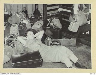 LAE, NEW GUINEA, 1945-05-07. PRIVATE I. WILLIAMS AWAITING THE CALL TO DISEMBARK FROM THE MV DUNTROON DURING TRANSIT TO THE AUSTRALIAN WOMEN'S ARMY SERVICE BARRACKS AT BUTIBUM ROAD