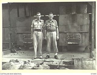 PORT MORESBY, NEW GUINEA. 1944-04-20. VX4279 LIEUTENANT R.J. MAILES (1) AND NX83632 SERGEANT A.H. BRACHER (2), BOTH ATTACHED FROM THE 13TH FIELD BAKERY COMPANY, PICTURED ALONGSIDE OVENS IN THE ..