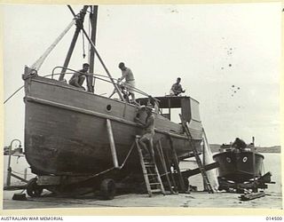 1943-03-24. NEW GUINEA. RAAF MOTOR BOAT CREWS IN NEW GUINEA OVERHAUL A BOAT WHICH ONCE DID THE ROUNDS OF THE LOBSTER POTS OFF THE N.S.W. COAST. WHEN IT LEAVES THIS IMPROVISED SLIPWAY IT WILL BE ..