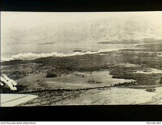 Nadzab, New Guinea. 1943-09-05. Smoke billows from behind low flying United States A20 (Boston) aircraft which are providing a smoke screen for a parachute landing of the American 503rd Parachute ..