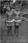 Friendship: adolescent girls in short fiber skirts, necklaces and garlands, girl (l) wears mourning necklace