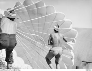 3 MILE, PORT MORESBY, NEW GUINEA. 1943-12-14. PERSONNEL OF THE 1ST AUSTRALIAN PARACHUTE REFOLDING PLATOON, AUSTRALIAN ARMY ORDNANCE CORPS, CHECKING A 24 FOOT AMERICAN CARGO DROPPING PARACHUTE FOR ..