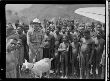 Missionary and Goat, Kerowagi, Papua New Guinea, having being transported on Qantas Empire Airways flight, including locals