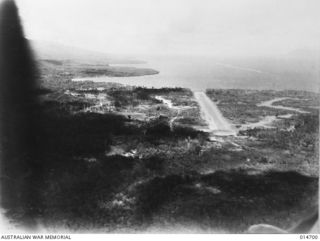 NEW GUINEA, MILNE BAY, 1943-04-20. AERIAL PHOTOGRAPH OF THE COASTAL STRIP WHERE THE MILNE BAY BATTLE WAS FOUGHT, SHOWING THE AIR STRIP WHERE HEAVY FIGHTING TOOK PLACE