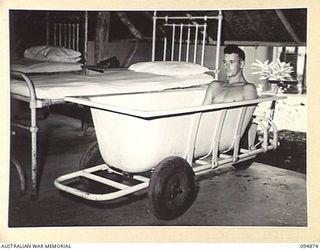 LAE AREA, NEW GUINEA. 1945-08-11. SERGEANT G. ANDERSON HAVING TREATMENT FOR BURNS IN A BATH USED FOR ALL BURN CASES AT 2/7 GENERAL HOSPITAL