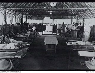 Goodenough Island, D'Entrecasteaux Islands, Papua, 1944-04-01. Interior of the airmen's ward of No. 5 Medical Receiving Station at the Headquarters of No. 71 Wing RAAF. The ward is a thatched hut ..