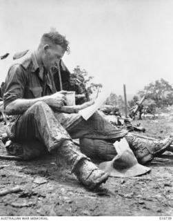 Just back from a patrol in the Finisterre Ranges, NX11483 Private Wallace William (Wal) Foster, 2/12 Battalion of Enmore NSW reads his mail