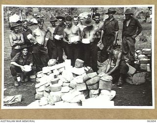 RAMU VALLEY, NEW GUINEA. 1943-12-22. PERSONNEL OF THE 2/31ST AUSTRALIAN INFANTRY BATTALION GATHER AROUND WHILE THE CHRISTMAS MAIL IS BEING SORTED