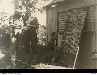 MADANG, NEW GUINEA. 1944-06-17. THE SCORE BOARD DURING THE TABLOID SPORTS MEETING CONDUCTED BY HEADQUARTERS 15TH INFANTRY BRIGADE. THE UNIT IS LOCATED IN THE SIAR PLANTATION. LEFT TO RIGHT: VX81072 ..