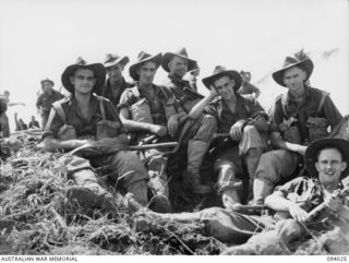 WEWAK AREA, NEW GUINEA, 1945-07-14. MEMBERS OF A COMPANY, 2/8 INFANTRY BATTALION, WHICH ASSAULTED "THE BLOT" WITH B COMPANY IN SUPPORT, RESTING AROUND A SHELL CRATER ON THE TOP OF "THE BLOT". ..