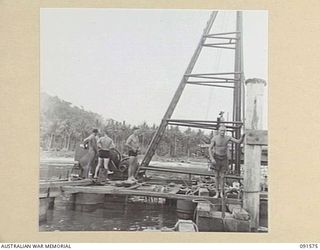 WIDE BAY, NEW BRITAIN. 1945-05-02. PERSONNEL OF 13 FIELD COMPANY, ROYAL AUSTRALIAN ENGINEERS, BESIDE A PILE DRIVER DURING CONSTRUCTION OF NEW DOCKS