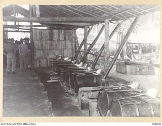 FAURO ISLAND, BOUGAINVILLE AREA. 1945-11-11. THE INTERIOR OF THE JAPANESE KITCHEN IN AREA NO. 7 SHOWING THE ARRANGEMENT OF COOKING POTS MADE FROM 44-GALLON DRUMS. THEY WERE PHOTOGRAPHED DURING A ..