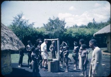 Administrative official weighing vegetables before payment at trade post : Wahgi Valley, Papua New Guinea, 1954-1955 / Terence and Margaret Spencer