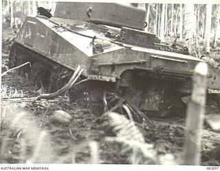 MADANG, NEW GUINEA. 1944-10-12. A SHERMAN M4A1 EQUIPPED WITH FLAT RUBBER TRACKS WITH GROUSERS, SUCCESSFULLY NEGOTIATING A TRACK IN WHICH TWO MATILDA TANKS HAD BEEN BOGGED DURING TESTS CONDUCTED AT ..