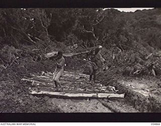 BULLDOG-WAU ROAD, NEW GUINEA, 1943-07-20. CORDUROY ROAD THROUGH MOSSY FOREST AT JOHNSON'S GAP, BEING LAID BY NATIVES, WHO ARE SUPERVISED BY THE TROOPS OF HEADQUARTERS, ROYAL AUSTRALIAN ENGINEERS, ..