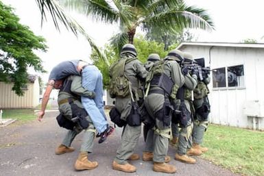U.S. Marine Corps Military Police remove a hostage, played by CPL. Harrick, with the Marine Forces Pacific Band, during training at the Marine Corps Base Hawaii on Dec. 9, 2004.(U.S. Marine Corps official photo by CPL. Nicholas Riddle) (Released)