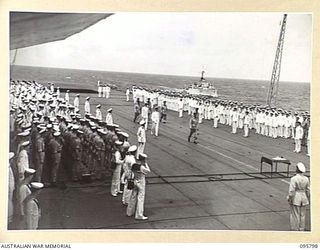 AT SEA OFF RABAUL, NEW BRITAIN. 1945-09-06. LIEUTENANT GENERAL V.A.H. STURDEE AND AUSTRALIAN OFFICERS WALKING ALONG THE FLIGHT DECK OF THE AIRCRAFT CARRIER HMS GLORY TOWARDS THE TABLE TO BE USED ..