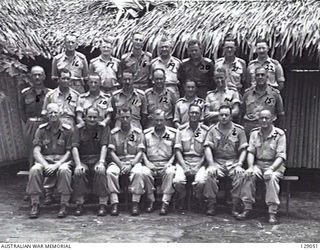 LAE, NEW GUINEA. 1945-12. AT 4TH ADVANCED ORDNANCE DEPOT. SHOWN, LEFT TO RIGHT, FRONT ROW: NX115557 CAPTAIN W. R. F. YATES; NX103737 MAJOR G. A. SEYMOUR-SMITH; VX21455 LIEUTENANT COLONEL J. B. ..