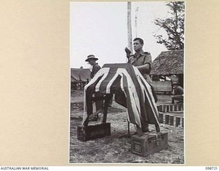 DALLMAN HARBOUR, NEW GUINEA. 1945-11-11. CHAPLAIN W.B. HOWDEN ADDRESSING TROOPS OF 2/5 INFANTRY BATTALION, DURING A MEMORIAL SERVICE HELD IN THE UNIT LINES IN HONOUR OF THOSE WHO FELL IN THE ..