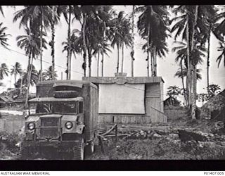 MADANG, NEW GUINEA. AUGUST 1945. RAAF NORTHERN COMMAND HEADQUARTERS. OUTDOOR PICTURE THEATRE WITH SIGN ABOVE THE CINEMA SCREEN READING "RAAF NC HIS MAJESTY'S THEATRE". (DONOR: M. ENGLISH)