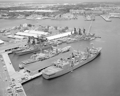 An aerial view of the Naval Shipyard with various ships moored to piers during Exercise RIMPAC '86