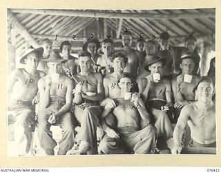 LAE, NEW GUINEA. 1944-10-03. TROOPS OF THE 12TH FIELD COMPANY, ENJOYING THEIR MORNING TEA DURING A BREAK IN PACKING EQUIPMENT AND STORES FOR THEIR NEW MOVE. IDENTIFIED PERSONNEL ARE:- TX10963 ..