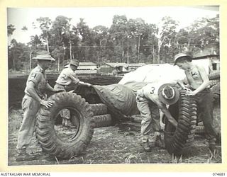 LAE-NADZAB, NEW GUINEA. 1944-07-25. PERSONNEL OF THE 8TH LINES OF COMMUNICATION SALVAGE DEPOT CHECKING TYRES AND OTHER RUBBER ARTICLES FOR SHIPMENT TO THE MAINLAND. IDENTIFIED PERSONNEL:- V246278 ..