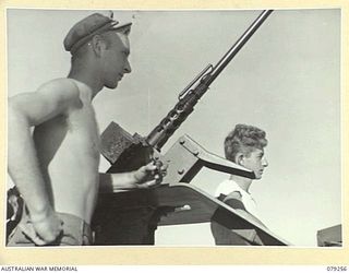WIDE BAY, NEW BRITAIN. 1945-02-17. GUNNERS OF THE 594TH ENGINEER BOAT AND SHORE REGIMENT B COMPANY, UNITED STATES ARMY STAND BY AS THEIR BARGE APPROACHES THE ENTRANCE TO HENRY REID BAY