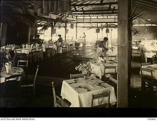 Ela Beach, New Guinea. 1944-05-22. The interior of the dining room at the Officers Club where the native boys are decorating the tables around the dance floor