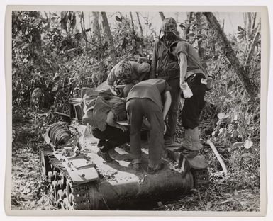 Photograph of Coast Guardsmen Examining a Destroyed Japanese Tank