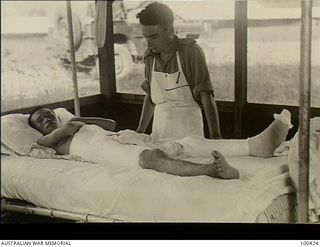 Port Moresby, New Guinea. 1944-05-09. SX39492 Lieutenant W. Hames, Physiotherapy Department, 128th Australian General Hospital, inspecting the plaster casing he made for this Japanese prisoner who ..