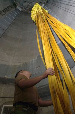 US Air Force (USAF) AIRMAN First Class (A1C) Oscar Hurtado from the 7th Expeditionary Maintenance Squadron (EMXS), untangles parachute cords to a B-52 Stratofortress bomber drag-chute, at Andersen Air Force Base (AFB), Guam