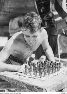 KIRIWINA, TROBRIAND ISLANDS, PAPUA. C. 1943-12. LEADING AIRCRAFTMAN D. PIDDINGTON CHECKS AUSTRALIAN-MADE SPARK PLUGS FOR THE TWO WRIGHT CYCLONE ENGINES OF BOSTON BOMBER AIRCRAFT OF NO. 22 SQUADRON ..