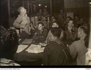 Lae, New Guinea. c. 1944-07-25. Dr Thomas Wood (1), author of the book "Cobbers" giving a lecture to members of the Writer's Club in the Australian Army Education Service Hut at HQ, New Guinea ..