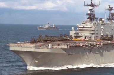 Marine Corps helicopters are parked on the forward flight deck of the amphibious assault ship USS SAIPAN (LHA-2) during NATO exercise NORTHERN WEDDING '86. The amphibious command ship USS MOUNT WHITNEY (LCC-20) is underway in the background