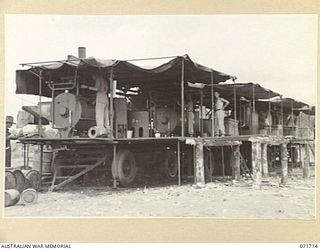 LAE, NEW GUINEA. 1944-03-25. MACHINERY IN USE BY MEMBERS OF THE 1ST MOBILE HOSPITAL LAUNDRY UNIT. THE TRAILER NEAREST THE CAMERA HAS WASHING FACILITIES. THE TRAILER AT THE CENTRE IS EQUIPPED WITH ..
