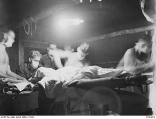 TAGESSI, BOUGAINVILLE ISLAND. 1945-01-16. NX402 MAJOR K.J. FRIEND, MEDICAL OFFICER, OPERATING ON A BATTLE CASUALTY FROM THE 47TH INFANTRY BATTALION AT THE MEDICAL DRESSING STATION OF THE 7TH FIELD ..