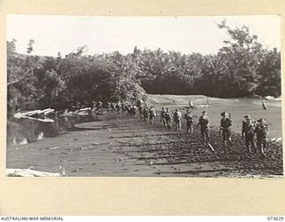 MANGEN (FURUK) RIVER, NEW GUINEA. 1944-05-28. FORWARD TROOPS OF THE 35TH INFANTRY BATTALION CROSSING THE BEACH HEAD AT THE RIVER DURING THEIR ADVANCE UP THE COAST TOWARDS WEWAK