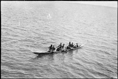 Seven people aboard a Mon canoe, New Guinea, ca. 1929 / Sarah Chinnery