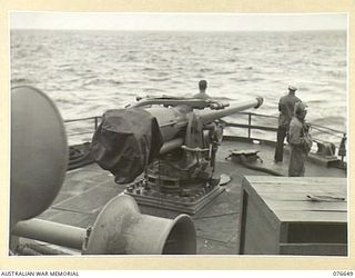 AT SEA. 1944-11. A UNITED STATES NAVY GUN CREW READY FOR ACTION ON THE STERN OF THE TROOPSHIP, "CAPE ALEXANDER" EN-ROUTE TO NEW BRITAIN