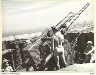 1942-11-06. SHOT OF AN AUSTRALIAN ANTI-AIRCRAFT BATTERY SOMEWHERE IN NEW GUINEA. THIS BATTERY IS MANNED ENTIRELY BY VICTORIANS USING GUNS MANUFACTURED IN A VICTORIAN FACTORY AND THEIR BAG OF ENEMY ..