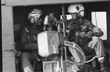 Crewmen aboard a UH-1 Iroquois helicopter prepare for takeoff from the amphibious assault ship USS GUAM (LPH 9), during operations off the coast of Beirut, Lebanon