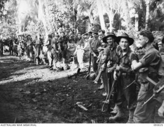 BOUGAINVILLE, 1945-06-07. TWO COMMANDO RAIDING PARTIES PREPARING TO MOVE OFF WITH NATIVE SCOUTS FROM NAIRONA VILLAGE, OUTLYING TROOP BASE FROM MOROKAIMORO, HELD BY B TROOP, 2/8 COMMANDO SQUADRON ..