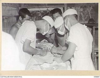 PIEDU ISLAND, SOLOMON ISLANDS. 1945-11-13. JAPANESE SURGEONS PERFORMING AN OPERATION, FOR THE REMOVAL OF A BULLET, IN THE IMPROVISED OPERATING THEATRE IN JAPANESE AREA 10. JAPANESE CONCENTRATED ON ..