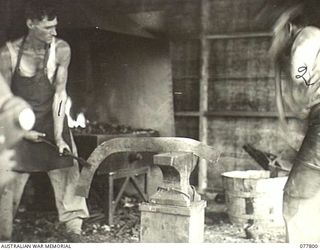 LAE BASE AREA, NEW GUINEA. 1944-12-27. QX39156 SAPPER M. THOMPSON (1) WORKING IN THE BLACKSMITH'S SHOP OF THE 13TH WORKSHOPS AND PARK COMPANY