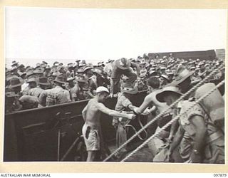 OFF BORAM BEACH, NEW GUINEA. 1945-10-13. THE FIRST BATCH OF TROOPS TO LEAVE THE WEWAK AREA UNDER THE PRIORITY DEMOBILISATION SCHEME WERE MEMBERS OF 6 DIVISION. SHOWN, TROOPS STEPPING OVER THE SIDE ..