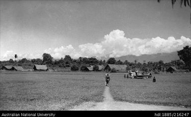 Airplane with people in a field near a village