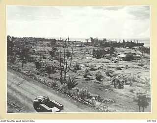 LAE, NEW GUINEA, 1944-03-27. ONE OF A SERIES OF PHOTOGRAPHS VIEWING THE WHARVES, SHIPPING, NEW ROADS, BUILDINGS AND THE AIRSTRIP WITH SALAMAUA POINT IN THE BACKGROUND. (JOINS WITH PHOTOGRAPHS ..