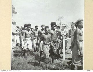 LAE, NEW GUINEA. 1944-09-12. NATIVES OF MALAHANG NATIVE COMPOUND ARRIVING AT A PARADE CONDUCTED BY THE ROYAL PAPUAN CONSTABULARY FOR THE PRESENTATION OF THE BRITISH EMPIRE MEDAL, (CIVIL DIVISION), ..